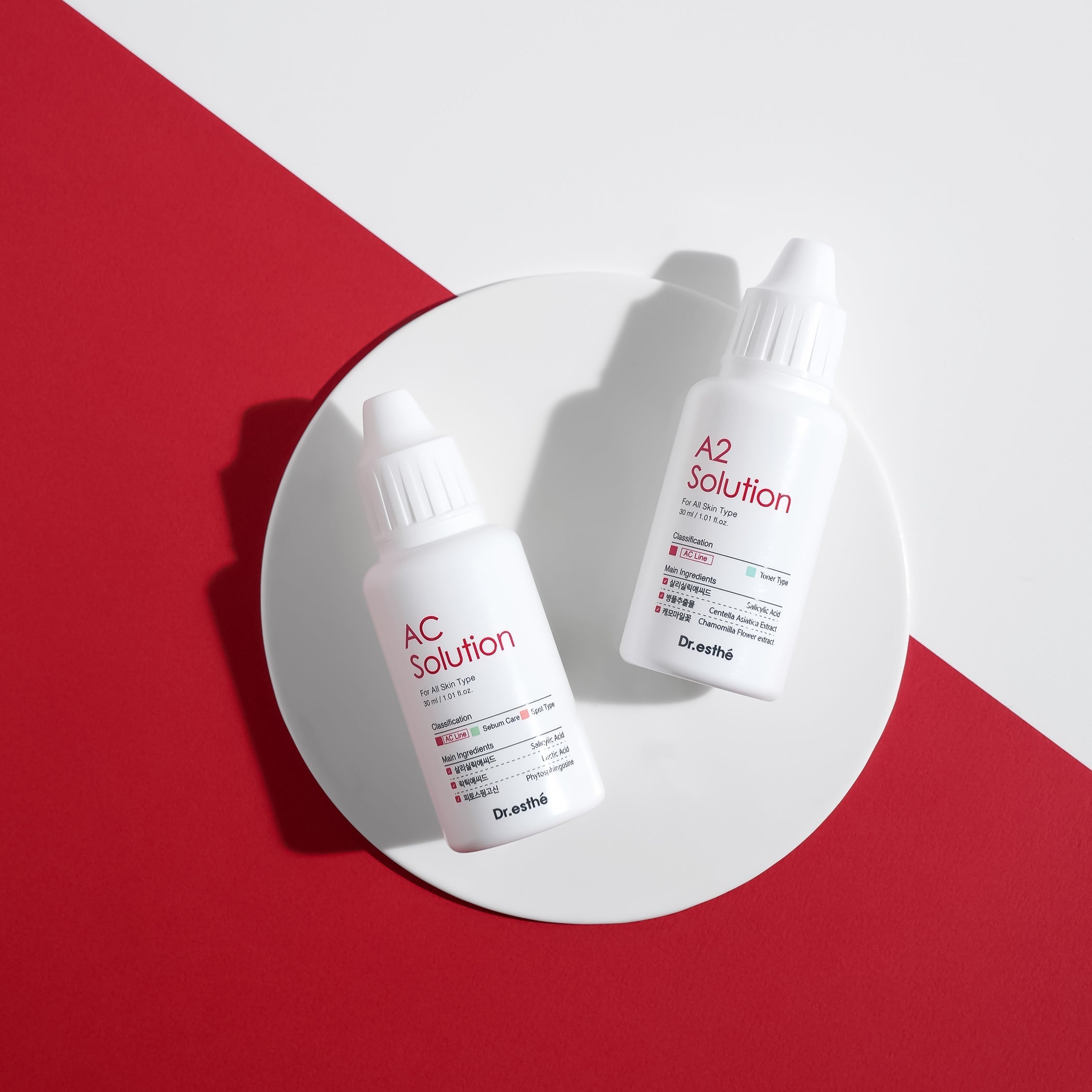 Two bottles of AC acne toner Solution and A2 acne toner solution on a white plate with a red background