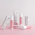 Cosmetic products with pink and white packaging on a light pink background