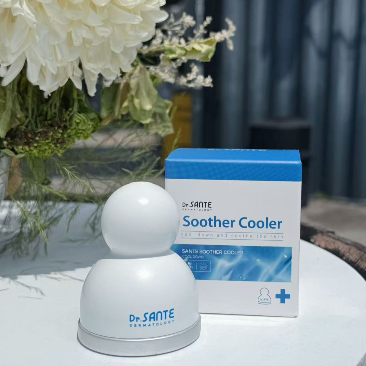 Dr. Sante Soother Cooler on a table with a box and white flowers in the background